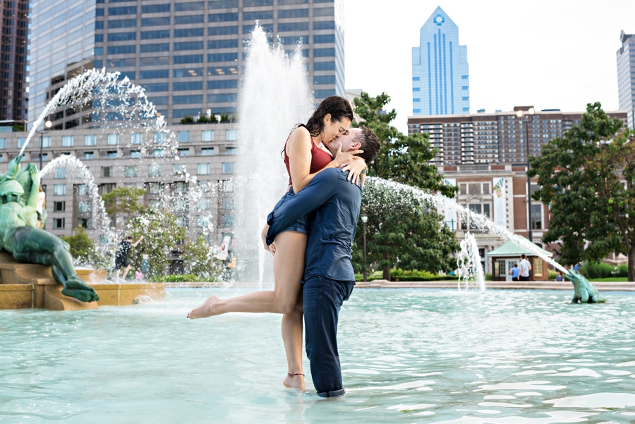 A couple kiss in the fountain at logan circle after playing in the water during their philly engagement session.